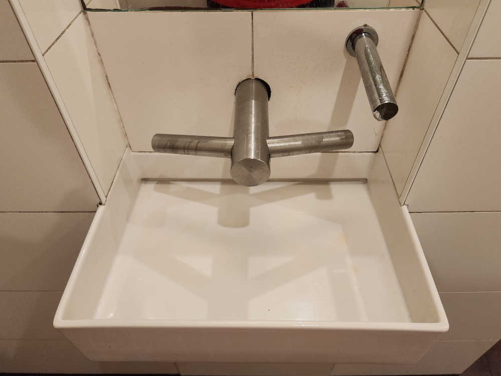 Moderne Sanitärtechnik - Wasserhan, Handtrockner und Seifenspender zu nah beinander